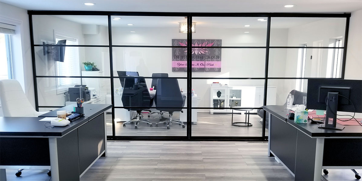 office with a conference room divided by 4 panels of sliding glass with a black grid design