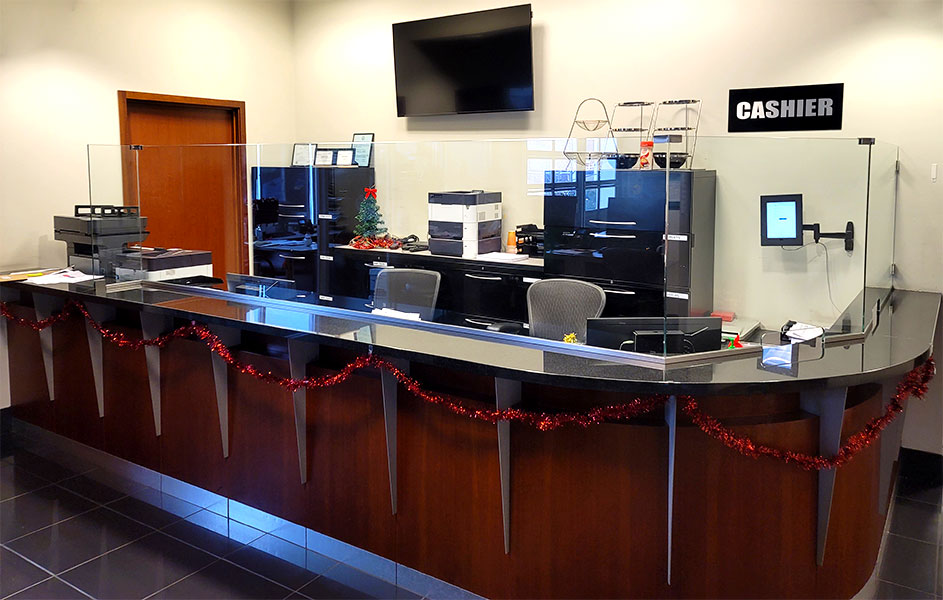 Car Dealership Cashier Desk with custom glass sneeze guards that has transaction window cut outs