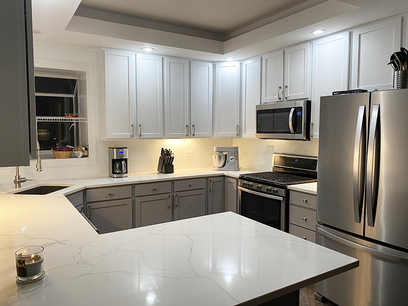 all white kitchen with stainless steel appliances and milk white glass kitchen backsplash