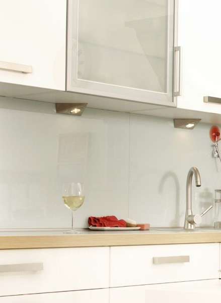 shiny white glass backsplash with white kitchen cabinets and brushed nickel door and drawer pulls