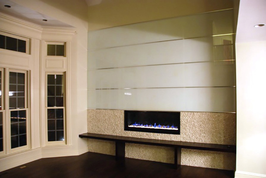 white back painted glass with chrome accents above fireplace