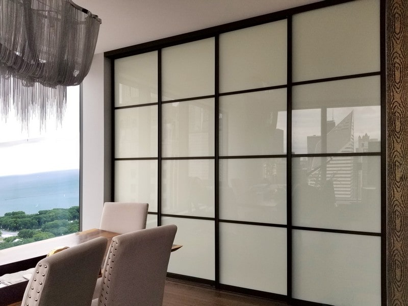 Dining room with white painted glass and black grid design sliding door room dividers