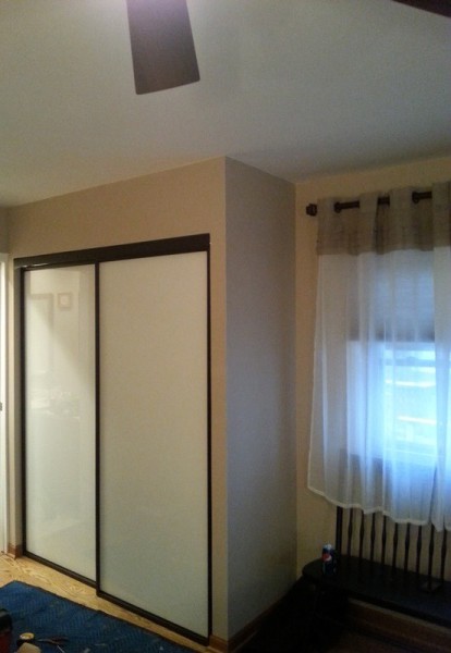 double bypass sliding doors with white back painted glass and black trim
